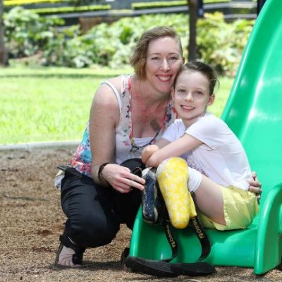 Nine year-old sepsis survivor Mia Wilkinson sitting on slide with mother Amy. Supplied.